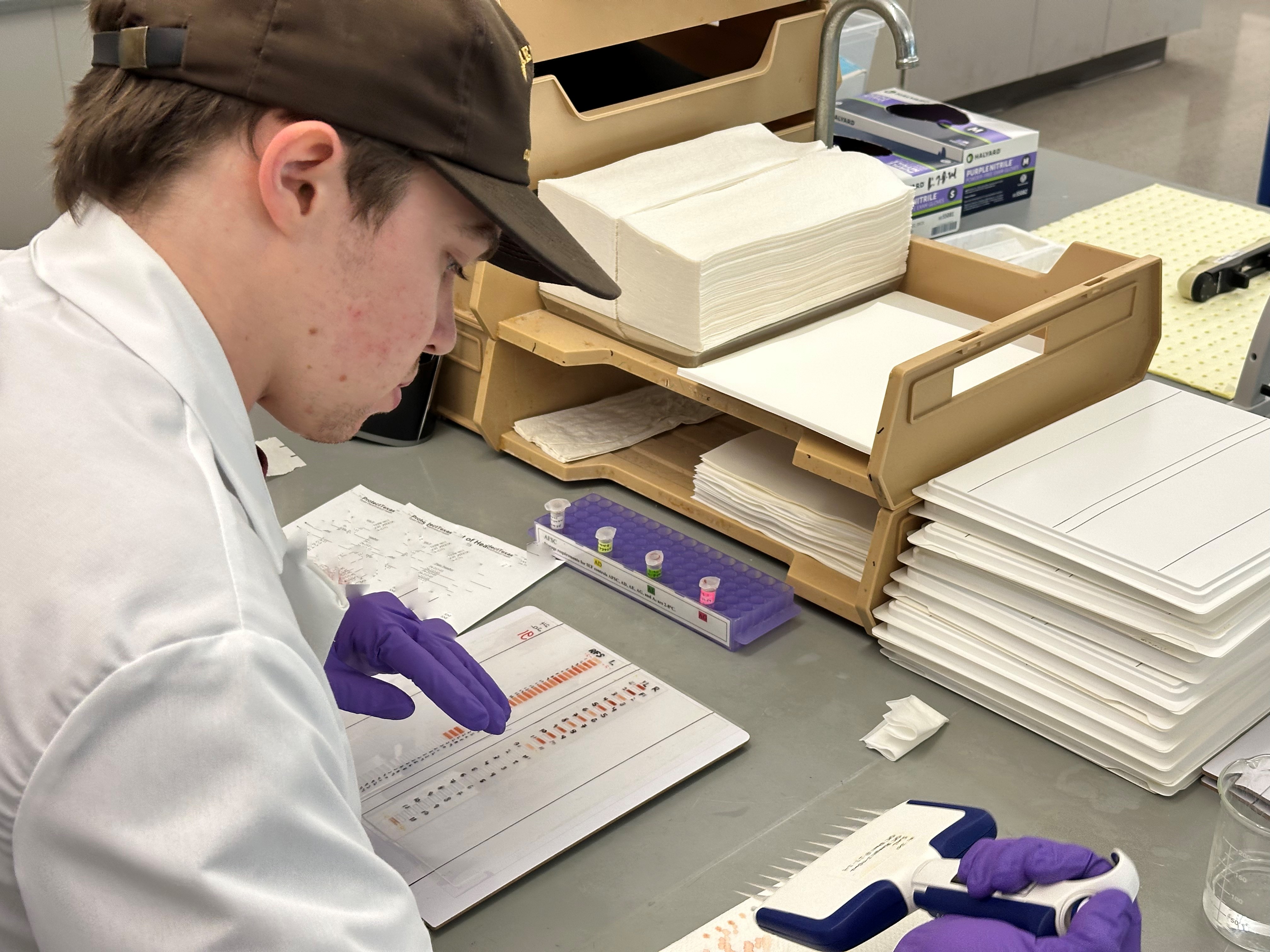 Lab Technician pipetting specimens onto a gel.  