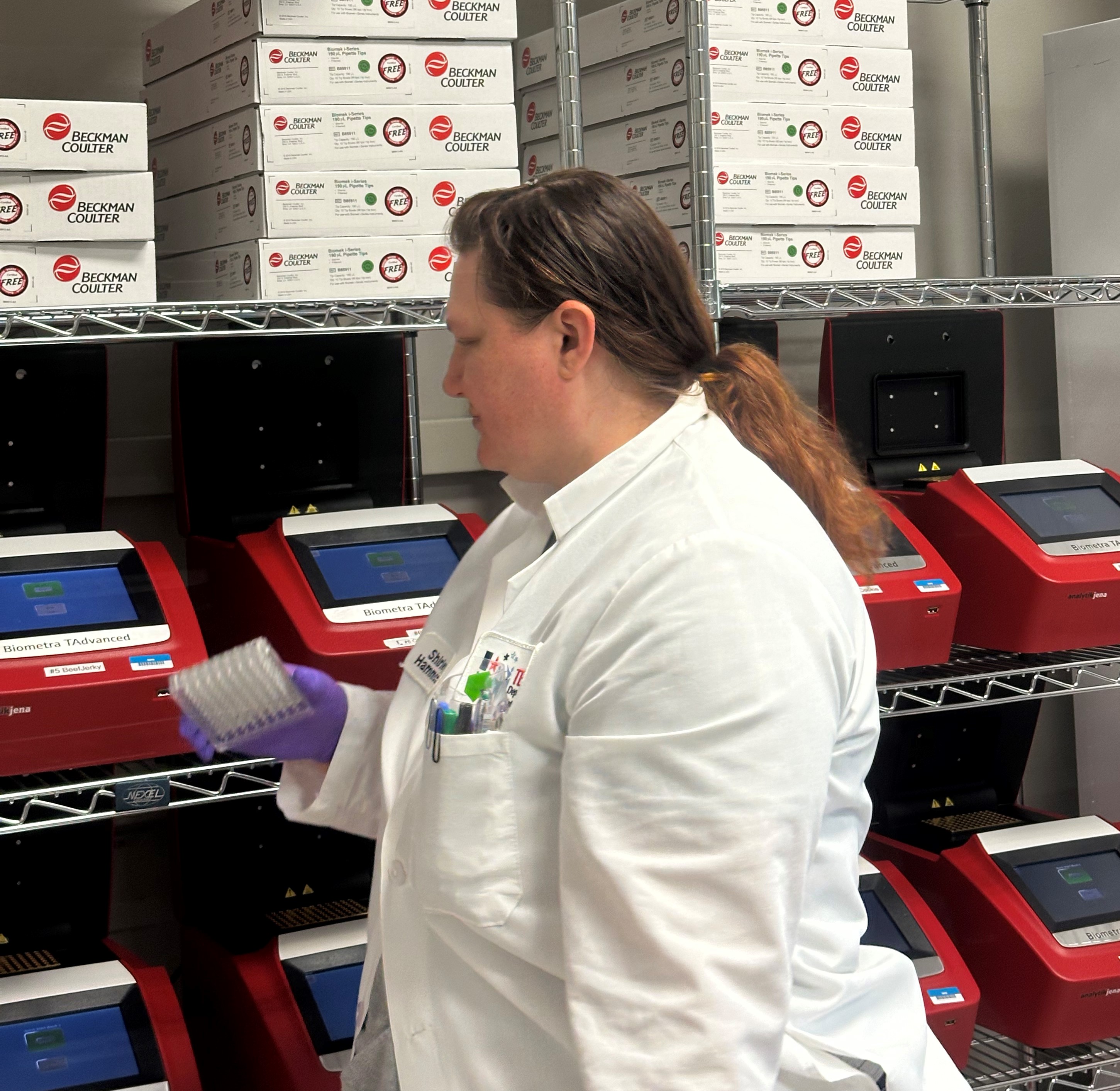 Lab Technician placing 96 well plate into an incubator  