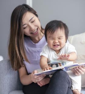 Happy mother reading with baby