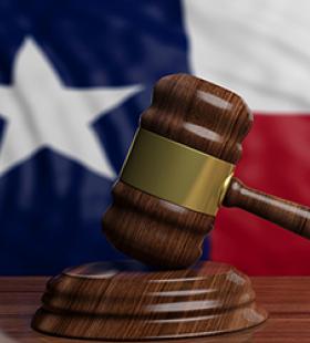 Gavel with Texas state flag behind it