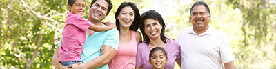 Three-generational family smiling at the camera.